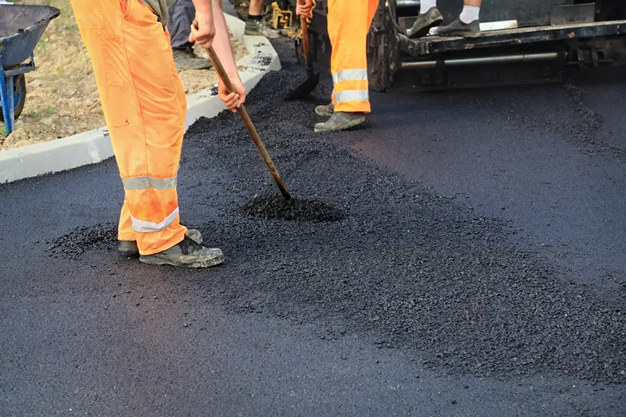 professionals pouring and smoothing out fresh asphalt for driveway - Collinsville, IL