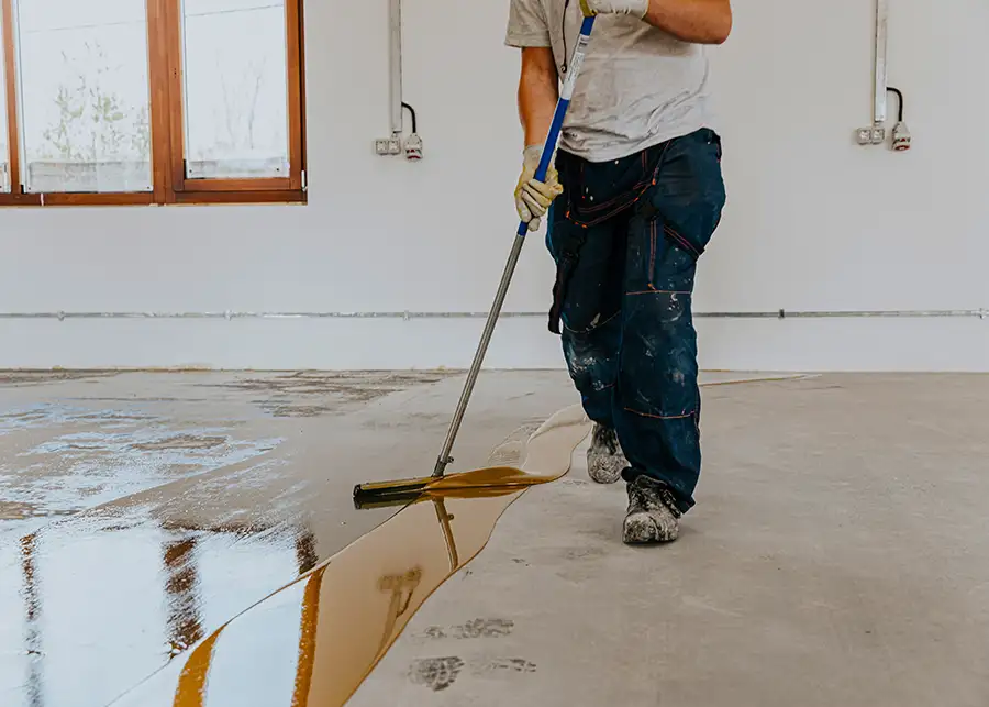 professional spreading concrete stain, resin over fresh poured concrete floor, rustic gold, reddish stain - Collinsville, IL